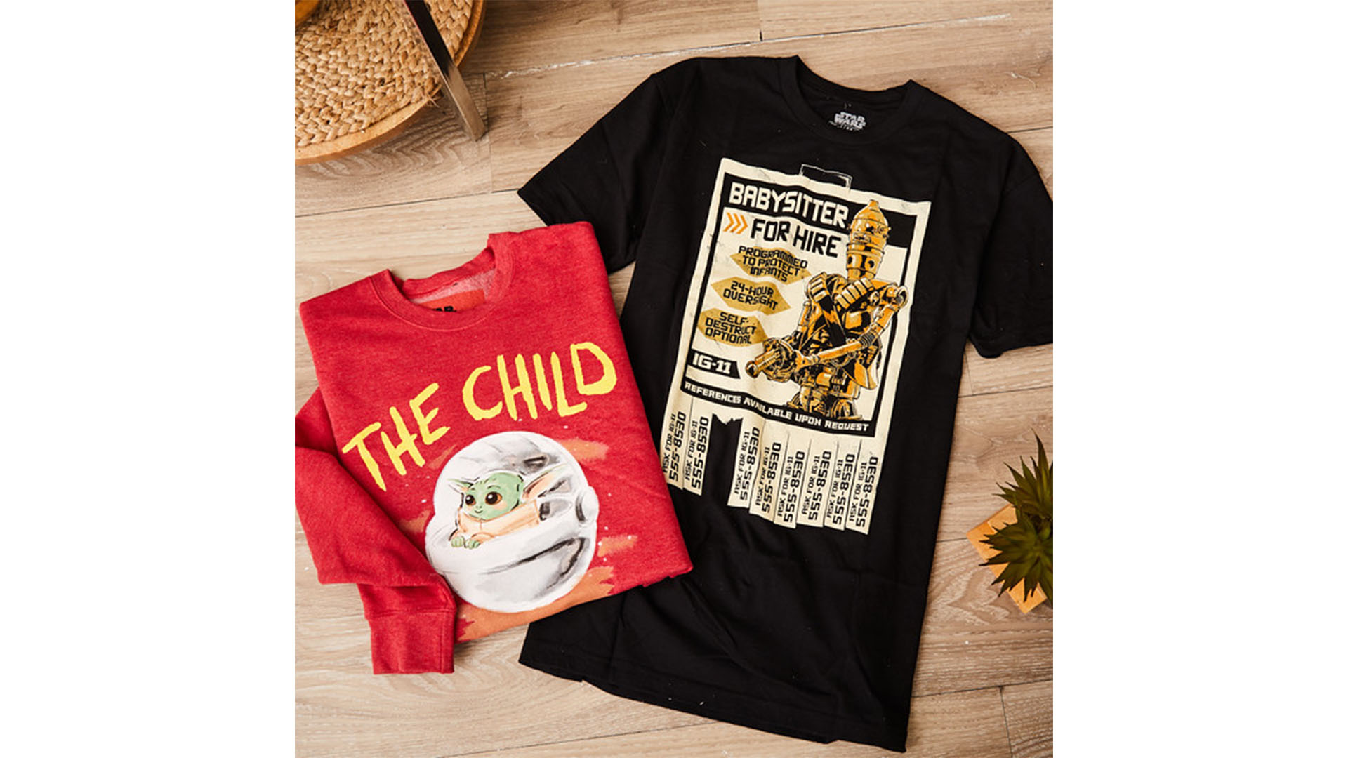 A folded red t-shirt featuring The Child and a black t-shirt featuring IG-11 from Star Wars: The Mandalorian.