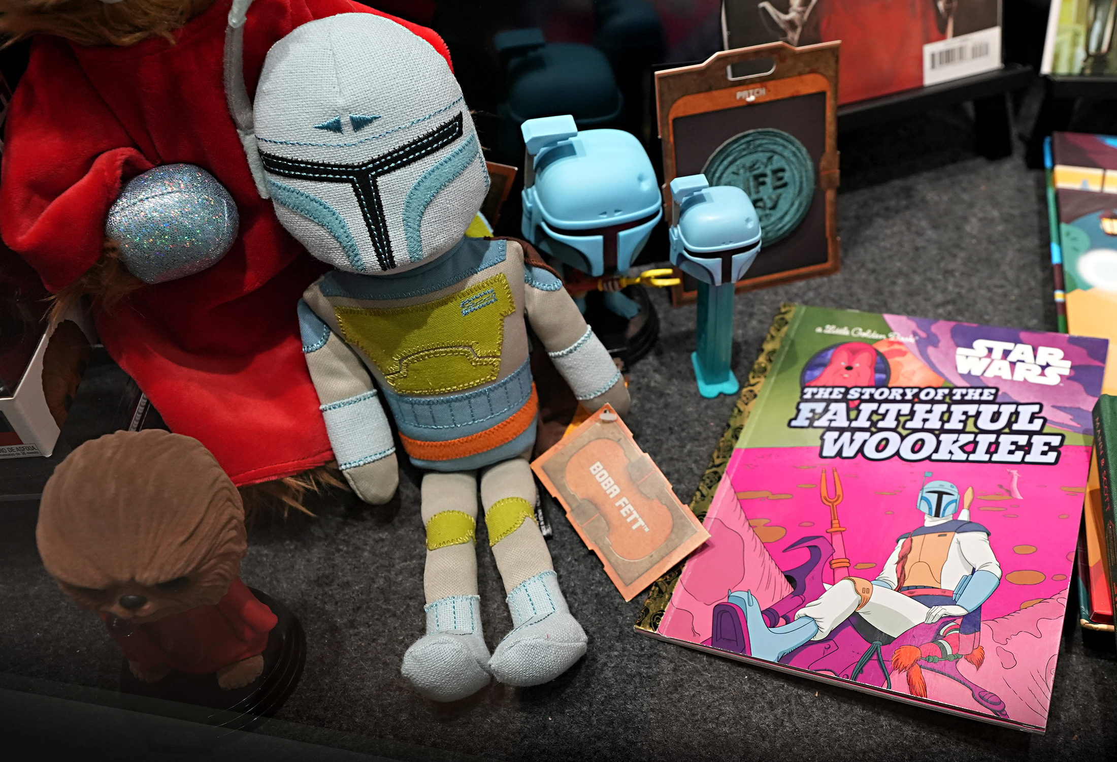 A few Boba Fetts are featured in the display, as the notorious bounty hunter made his debut in the Holiday Special’s brief animated sequence. Fett’s unique blue coloring resembles his appearance in the cartoon, and the Boba Fett plush depicted here was only available for a limited time at Disney Parks’ Star Wars: Galaxy’s Edge.