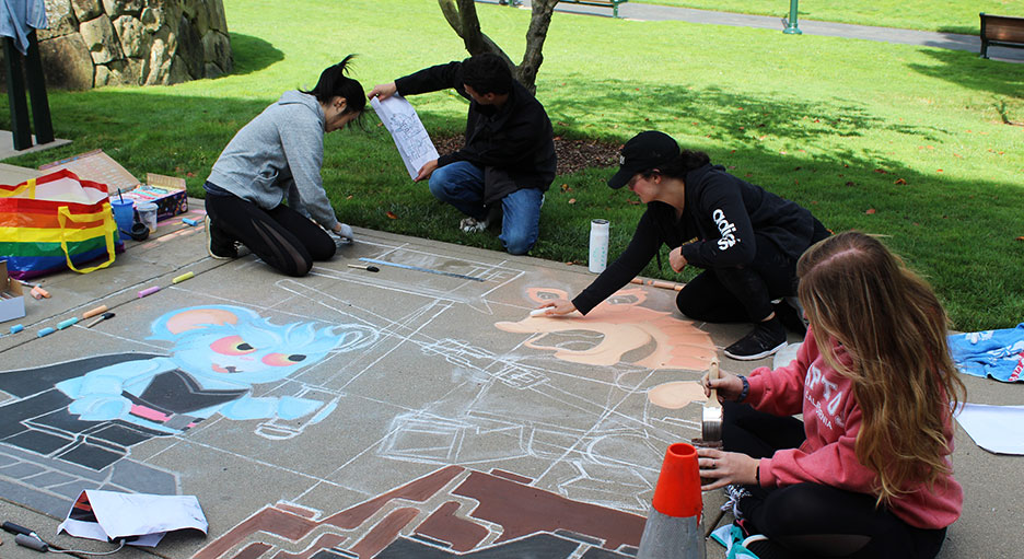 Employees creating art work at the Lucasfilm sidewalk chalk festival.