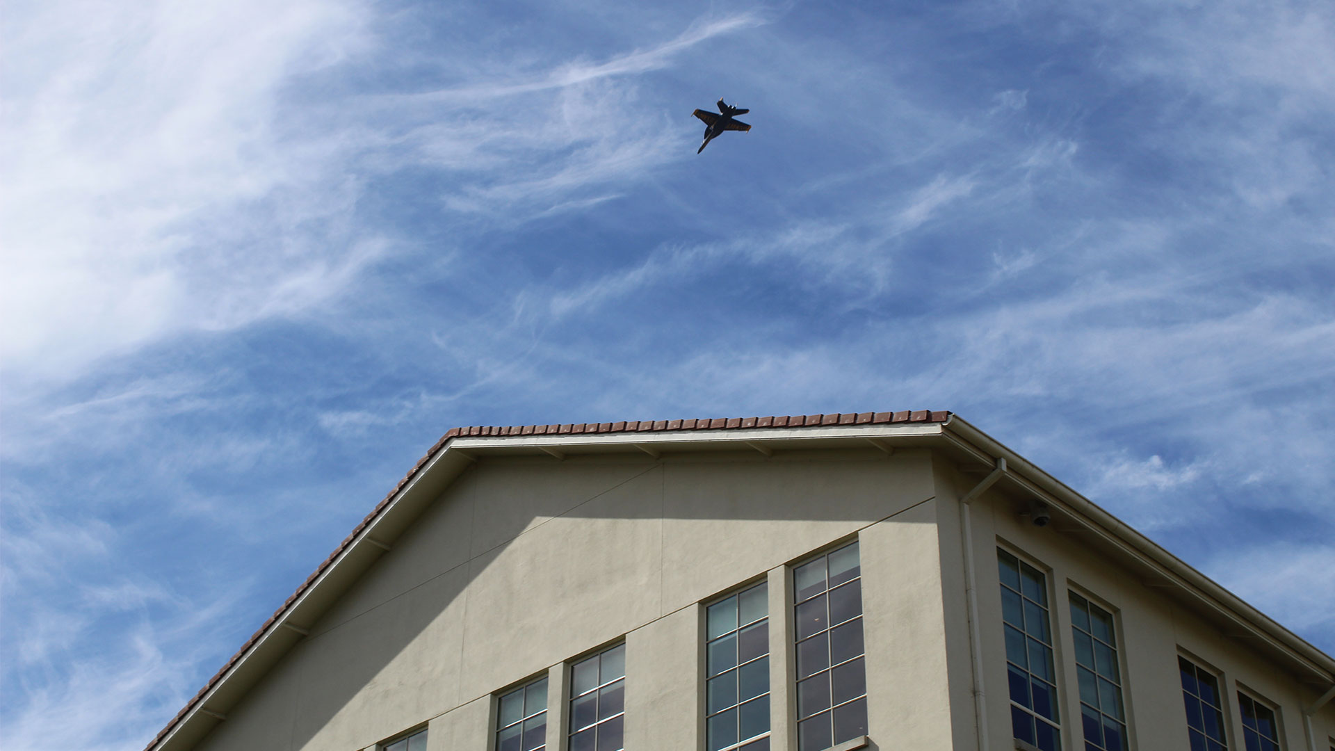 One of the U.S. Navy Blue Angels flies overhead.